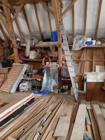 Dachboden mit Holzlatten, Bauholz, Leiter und Werkzeugen für Renovierung und Heimwerken.